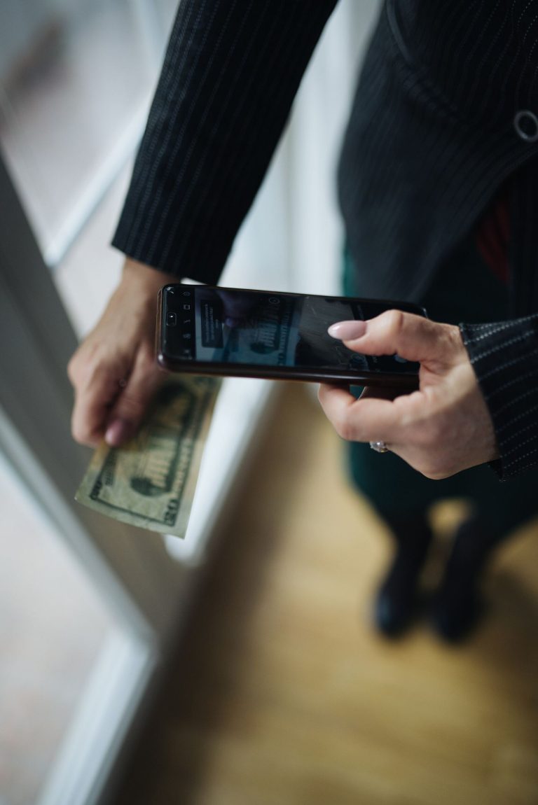 Crypto Wallet Apps Put New Focus on Security A hand holds a smartphone displaying a crypto wallet app with account balances.