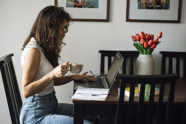 Long-Form Writing Refuses to Die Online A writer working on a laptop with a cup of coffee at a desk.